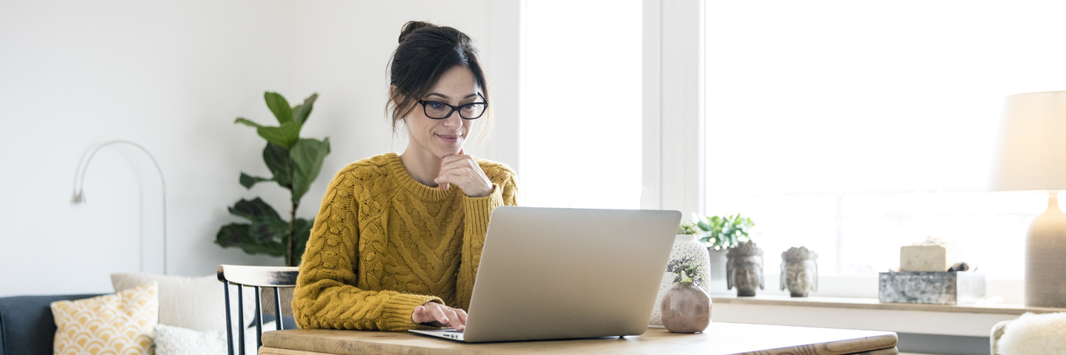 Woman sitting at home in front of her laptop